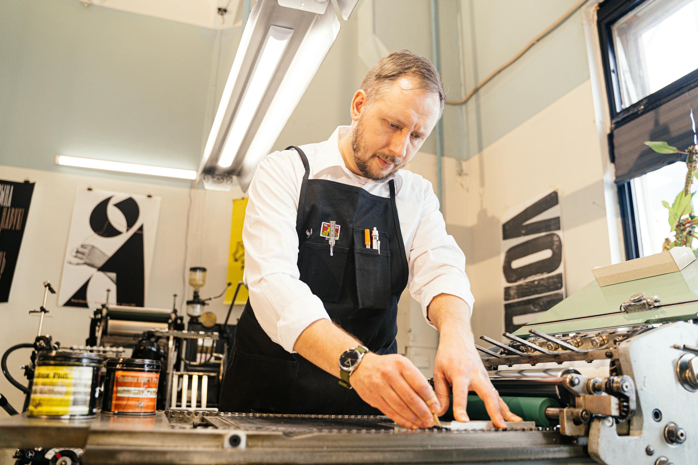 A craftsman at work in a bright, well-equipped print workshop.