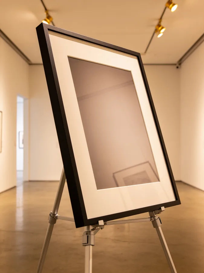 Display easel holding a mounted print in studio lighting